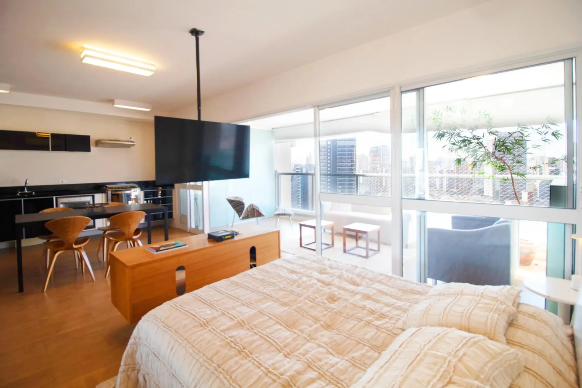 Studio urbano com cama, cozinha integrada e vista para a cidade antes do tratamento